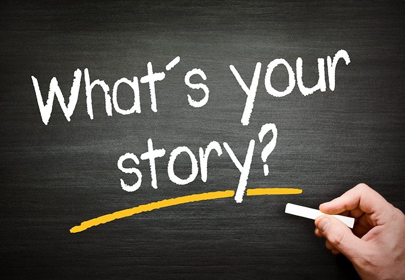 A chalkboard with the words " what 's your story ?" written in chalk.